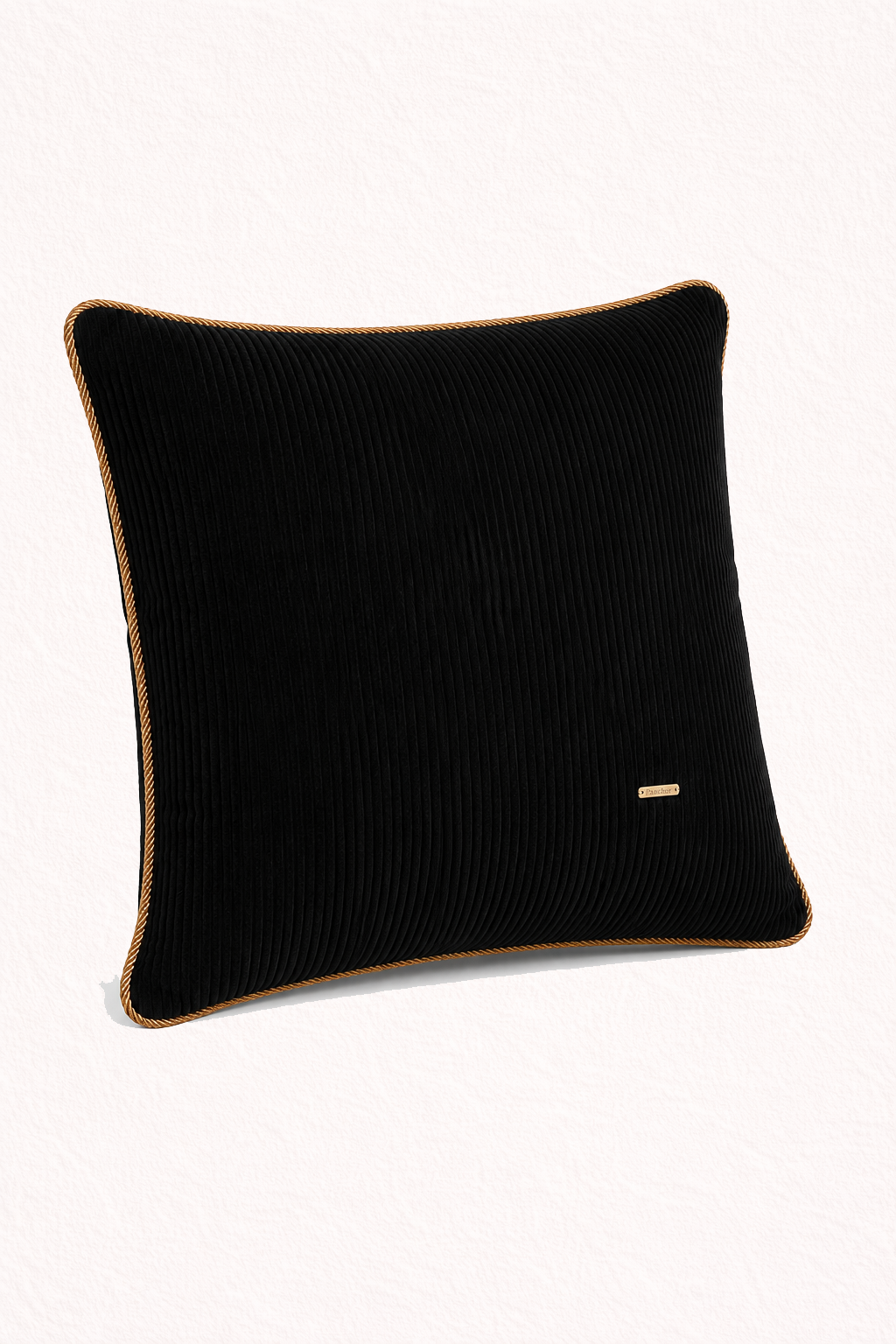 Black ribbed pillow with a small gold tag on a white background