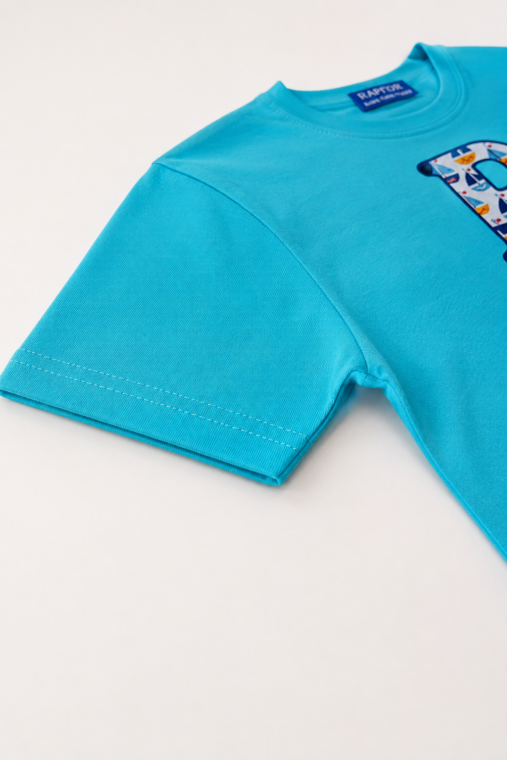 Blue t-shirt with a colorful graphic on a light gray background