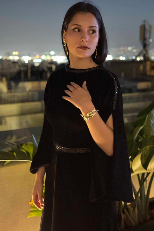 Woman in a black outfit with a blurred cityscape background