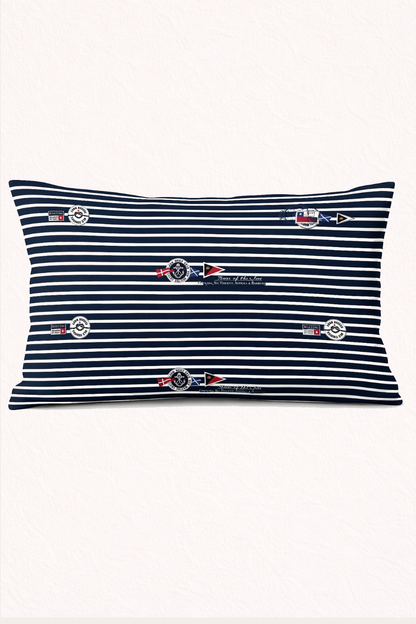 Nautical-themed bedroom with striped pillows and decorative items on a shelf.