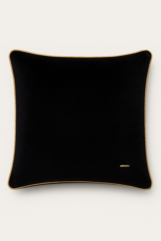 Black pillow with gold trim on a white background