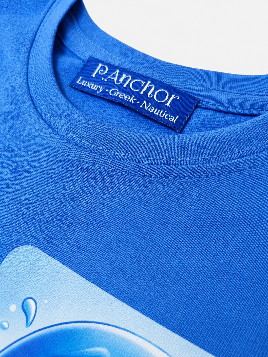 Close-up of a blue t-shirt with a brand label on a light gray background