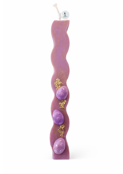 Wavy purple candle with gold accents on a white background