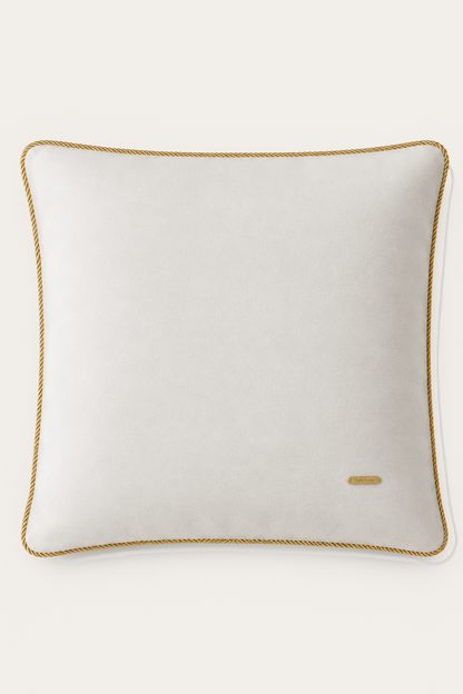 Ivory pillow with gold trim on a white background