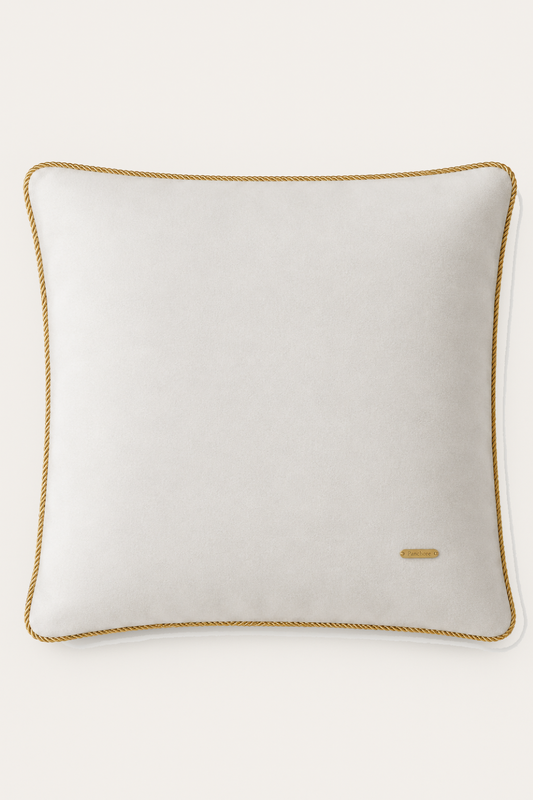 Ivory pillow with gold trim on a white background