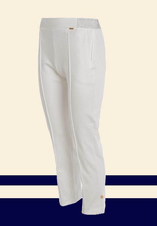 "White unisex trousers with a silver glitter waistband and a gold button detail at the ankle, featuring a clean front seam and side pockets."